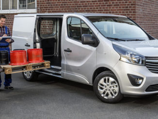 Ein silberner Opel Vivaro B Panel Van wird von einem Gabelstapler mit einer Palette beladen.