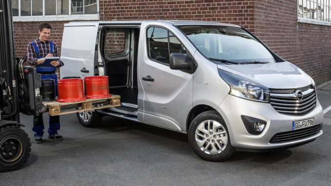 Ein silberner Opel Vivaro B Panel Van wird von einem Gabelstapler mit einer Palette beladen.