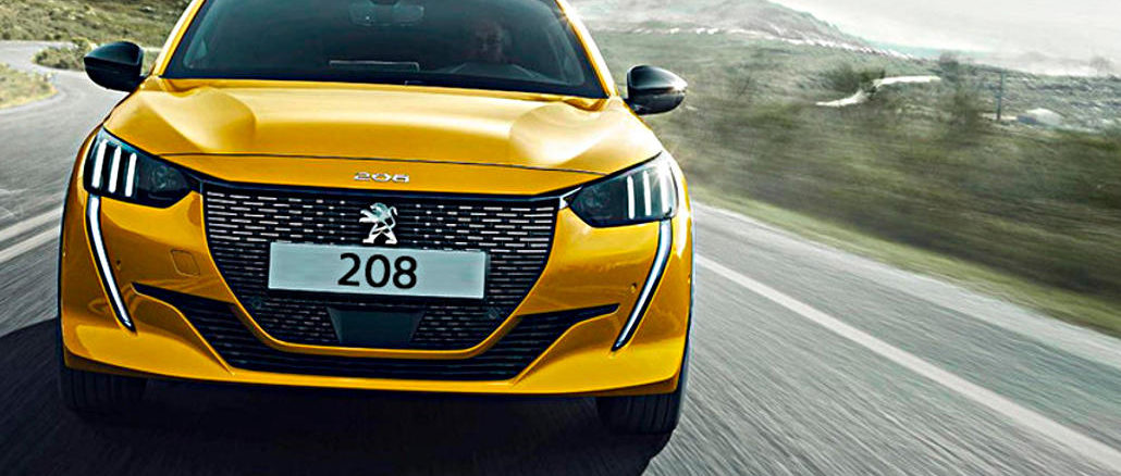 Ein goldgelber Peugeot 208 der zweiten Generation steht 2019 fährt auf einer Landstraße..