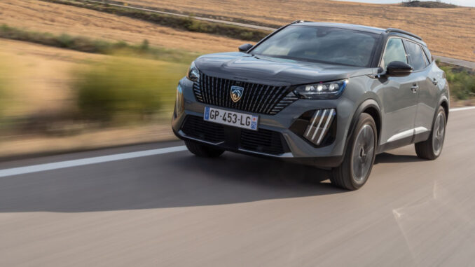 Ein grauer Peugeot 2008 fährt 2023 über eine französische Landstraße.