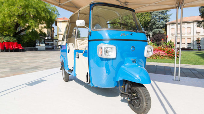 Eine blaue piaggio_ape_calessino steht 2018 unter einer Pergola.