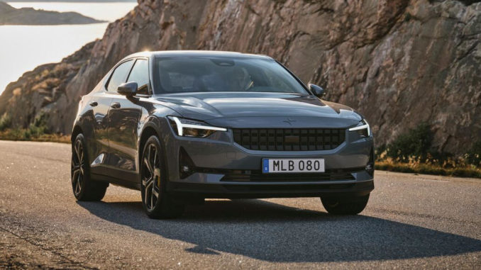 Ein grauer Polestar 2 fährt 2020 auf einer schwedischen Landstraße an einer Felswand vorbei.