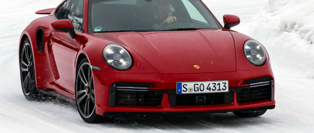 Porsche Winter-Event 2022 - ein roter 911 Turbo S fährt um eine verschneite Kurve.