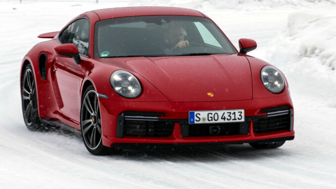 Porsche Winter-Event 2022 - ein roter 911 Turbo S fährt um eine verschneite Kurve.
