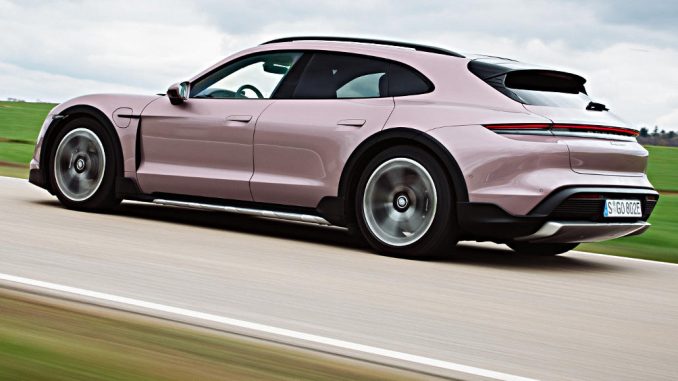 Ein Porsche Taycan 4 Cross Turismo in frozenberrymetallic fährt 2021 auf einer Landstraße.