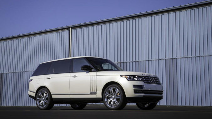 Ein weißer Range Rover steht vor einer fesnterlosen Wand.