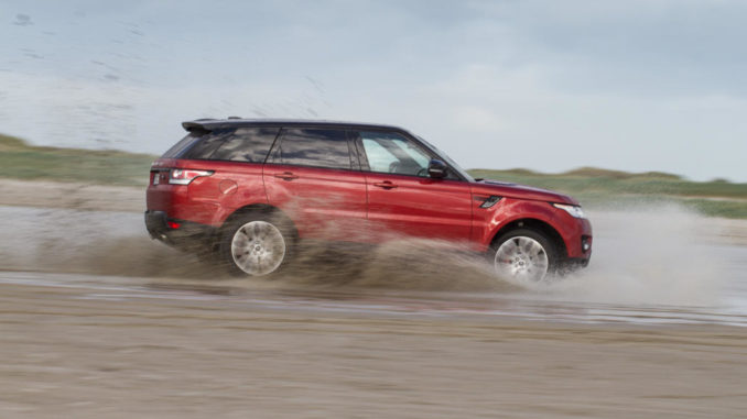 Ein roter Range Rover Sport fährt 2018 durch Schlamm.