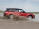 Ein roter Range Rover Sport fährt 2018 durch Schlamm.