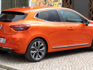 Ein orangener Renault Clio V steht 2019 vor einer Graffitiwand.