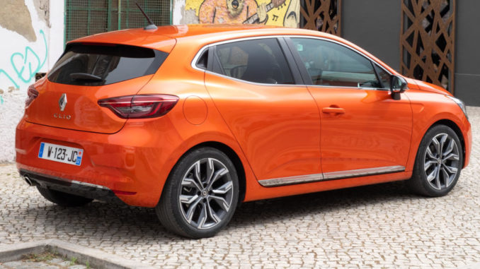 Ein orangener Renault Clio V steht 2019 vor einer Graffitiwand.