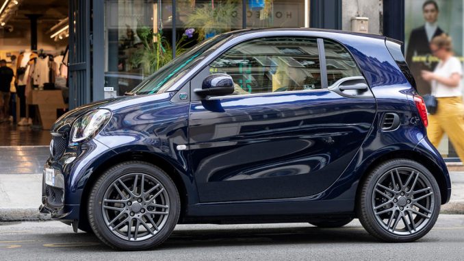 Ein blauer Smart Fortwo steht 2019 vor einem Ladengeschäft.