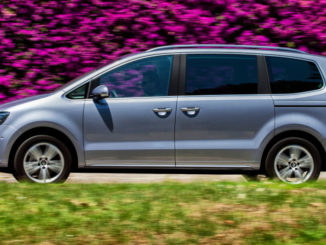 Ein silberner Seat Alhambra fährt 2015 an einer Blumenhecke vorbei.