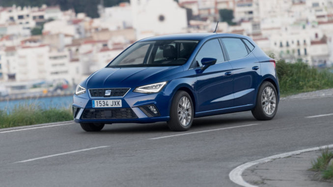 Ein blauer Seat Ibiza fährt 2017 auf einer Küstenstarße.