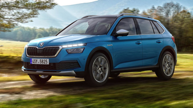 Ein blauer Skoda Kamiq fährt im Herbst 2019 durch einen Wald.