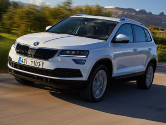 EIn weißer Skoda Karoq fährt über eine südeuropäische Landstraße.