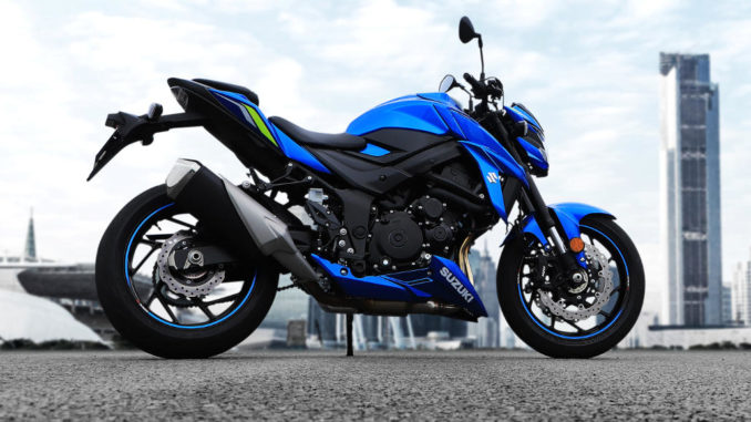 Eine blaue Suzuki GSX-S750 steht auf einer Betonfläche vor einer Skyline.