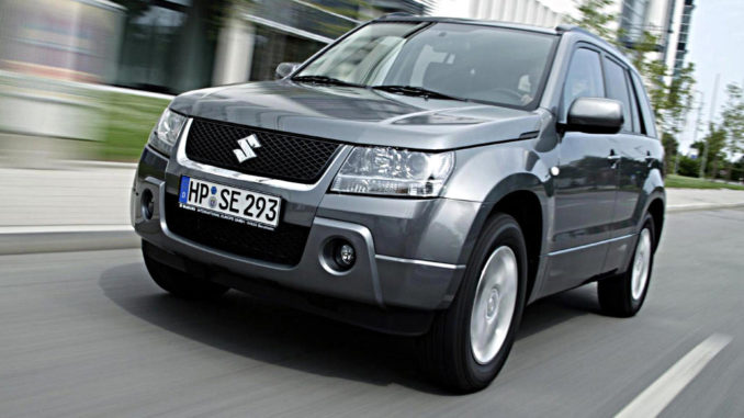 Ein silberner Suzuki Grand Vitara fährt 2005 an einem Bürogebäude vorbei.