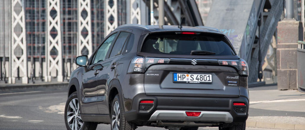 Ein grauer Suzuki S-Cross steht 2022 vor einer Stahlbrücke.