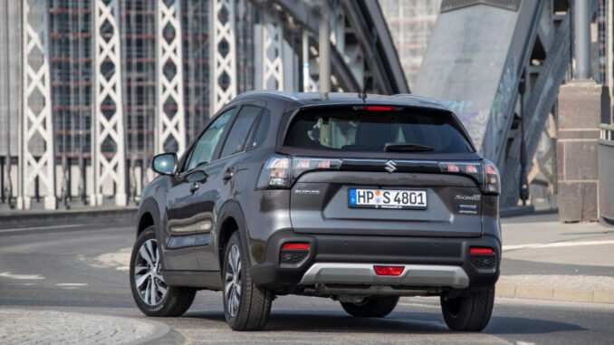 Ein grauer Suzuki S-Cross steht 2022 vor einer Stahlbrücke.