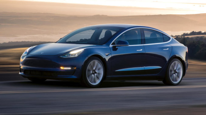 Ein blauer Tesla Model 3 fährt 2018 durch eine Wüstenlandschaft.