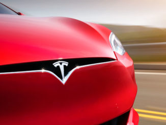 Ein roter Tesla Model S fährt 2017 auf einer US-amerikanischen Landstraße.
