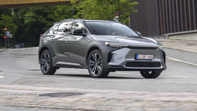 Ein grauer Toyota bz4x steht 2022 vor einem Gebäude.