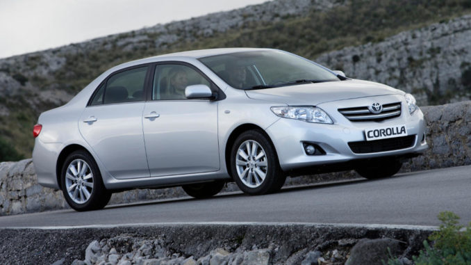 Ein silberner Toyota Corolla steht 2008 vor einer Steinmauer.