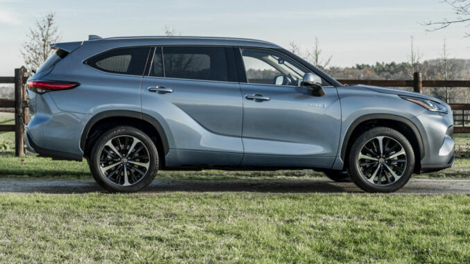 Ein blaugrauer Toyota Highlander steht 2020 vor einer Pferdekoppel.