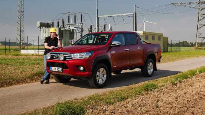 Ein roter Toyota Hilux steht 2018 vor einem Schaltwerk.