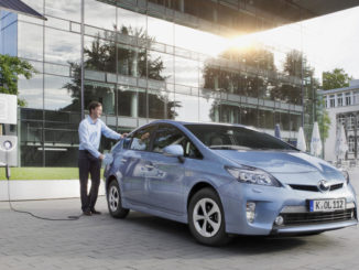 Ein blauer Toyota Prius PHV steht 2014 an einer Ladesäule.