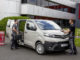 Ein beiger Toyota Proace wird von zwei Handwerkern beladen.