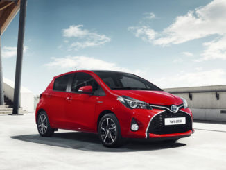 Ein roter Toyota Yaris Style steht 2016 unter einer Brückenkonstruktion.