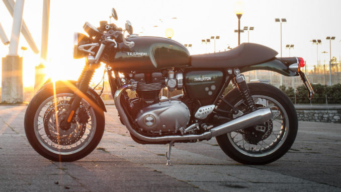 Eine grüne Triumph Thruxton steht 2016 im Abendlicht.