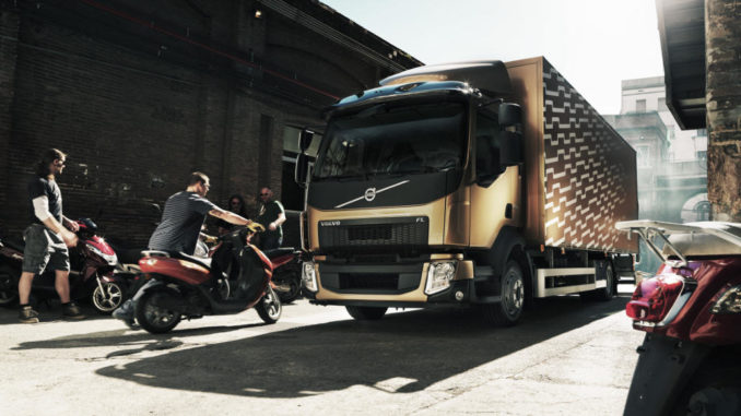 Ein kupferfarbender Volvo FL wird mit Rollern beladen