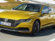 Ein goldener VW Arteon fährt durch eine verschneite Landschaft.