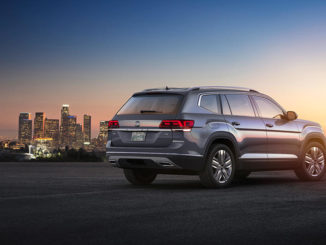 Ein grauer Volkswagen Atlas steht in den USA vor der Skyline einer Großstadt.