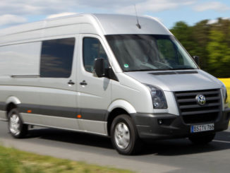 Ein grauer VW Crafter fährt 2009 an einem Rapsfeld vorbei.