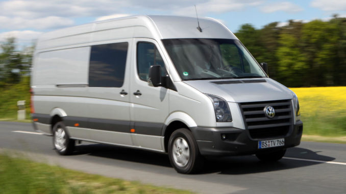 Ein grauer VW Crafter fährt 2009 an einem Rapsfeld vorbei.