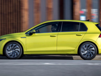 Ein gelber VW Golf 8 fährt 2019 durch eine Großstadt.