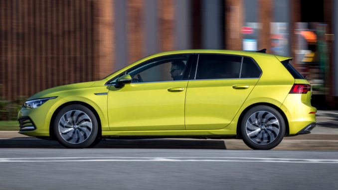 Ein gelber VW Golf 8 fährt 2019 durch eine Großstadt.