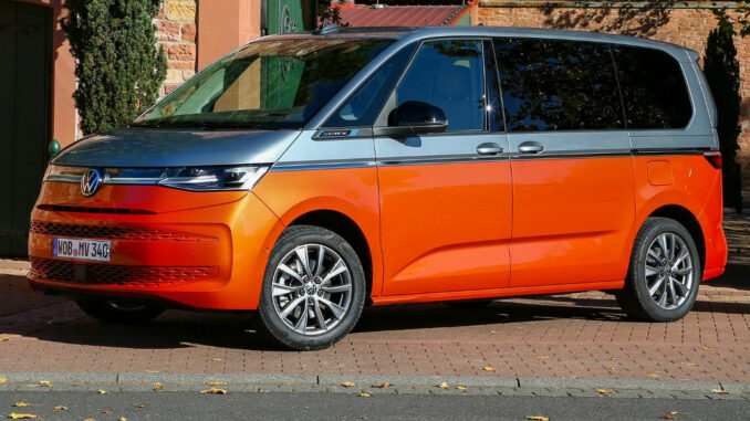 Ein silber-oranger VW Multivan T7 steht im Herbst 2021 vor einer Hofeinfahrt.