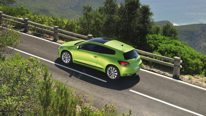 Ein grüner Volkswagen Scirocco fährt 2008 auf einer Küstenhochstraße.