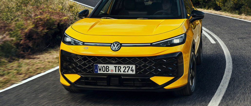 Ein gelber VW T-Roc der zweiten Generation fährt 2025 um eine Kurve auf einer Landstraße.