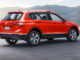 Ein roter VW Tiguan steht in den USA vor einem Bergsee.