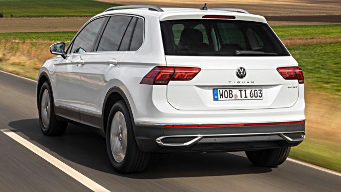 Ein weißer VW Tiguan eHybrid fährt 2020 auf einer Landstraße.