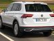 Ein weißer VW Tiguan eHybrid fährt 2020 auf einer Landstraße.