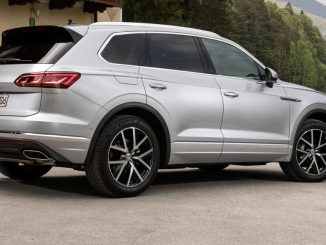 Ein silberner VW Touareg Elegance steht 2018 vor einem Haus in den Alpen.