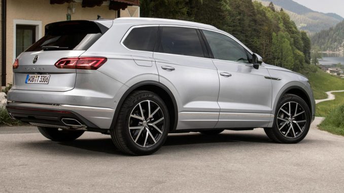 Ein silberner VW Touareg Elegance steht 2018 vor einem Haus in den Alpen.