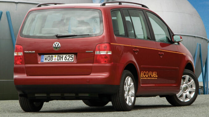 Ein roter VW Touran EcoFuel von Volkswagen mit Erdgasantrieb steht 2006 vor Gastanks.