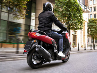 Eine rote yamaha nmax125 fährt 2020 durch eine Großstadt.